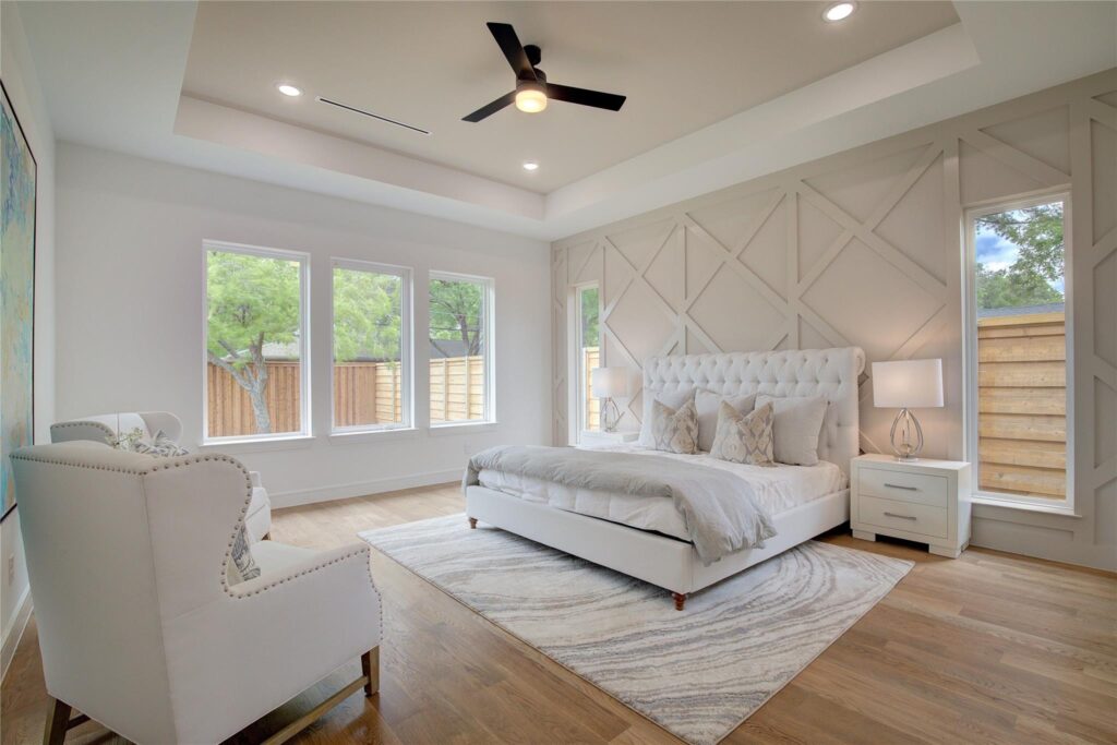 Elegant bedroom with neutral tones and modern ceiling fan.