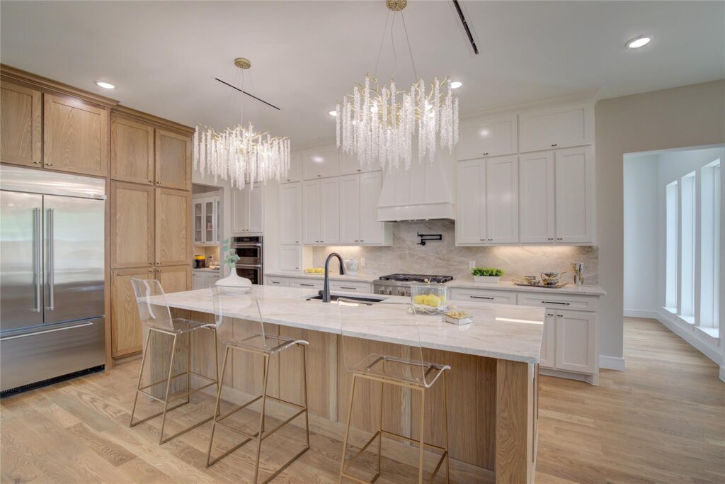 Modern kitchen with white and wood design and elegant lighting.