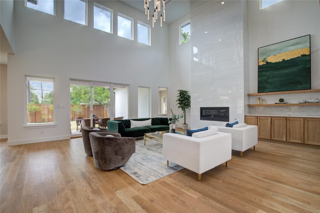 Bright modern living room with white furniture and large windows.