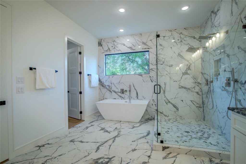 Luxurious bathroom with marble floors and a freestanding bathtub.