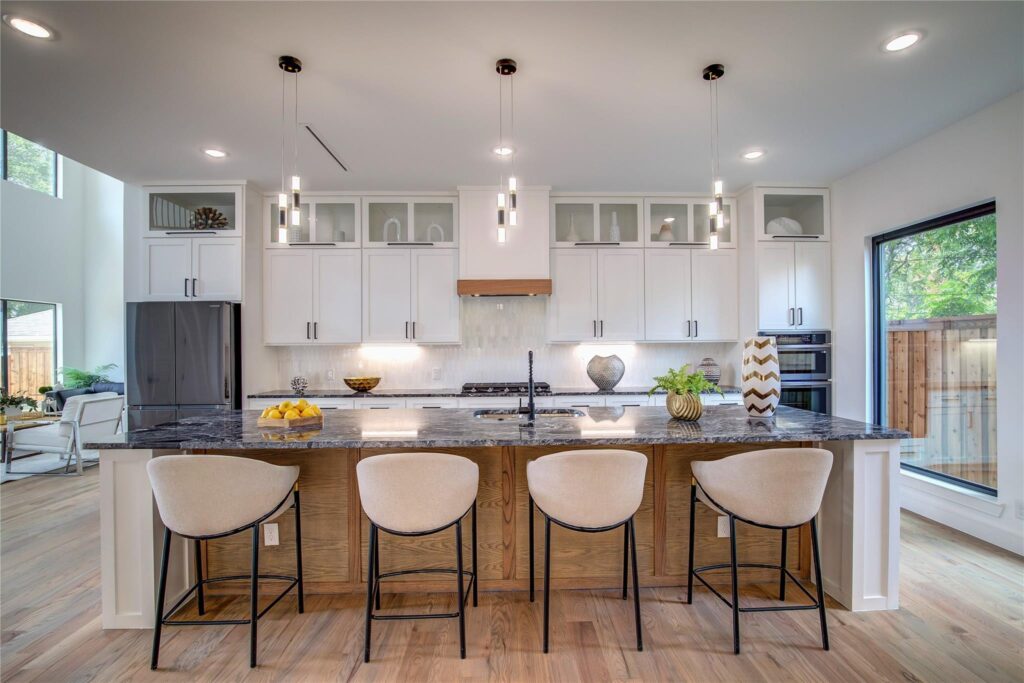 Modern kitchen with island and pendant lights.