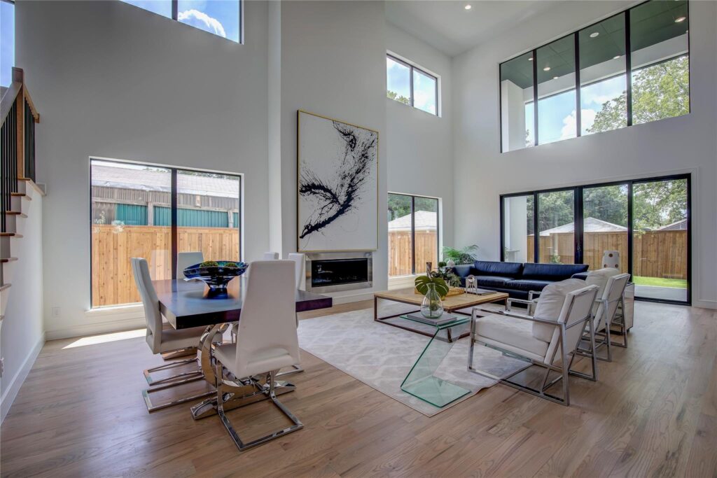 Modern living room with high ceilings, large windows, and minimalist furniture.