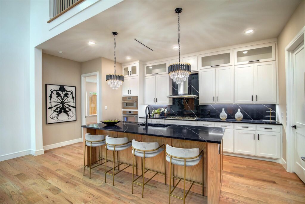 Modern kitchen with a large island and stylish pendant lights.
