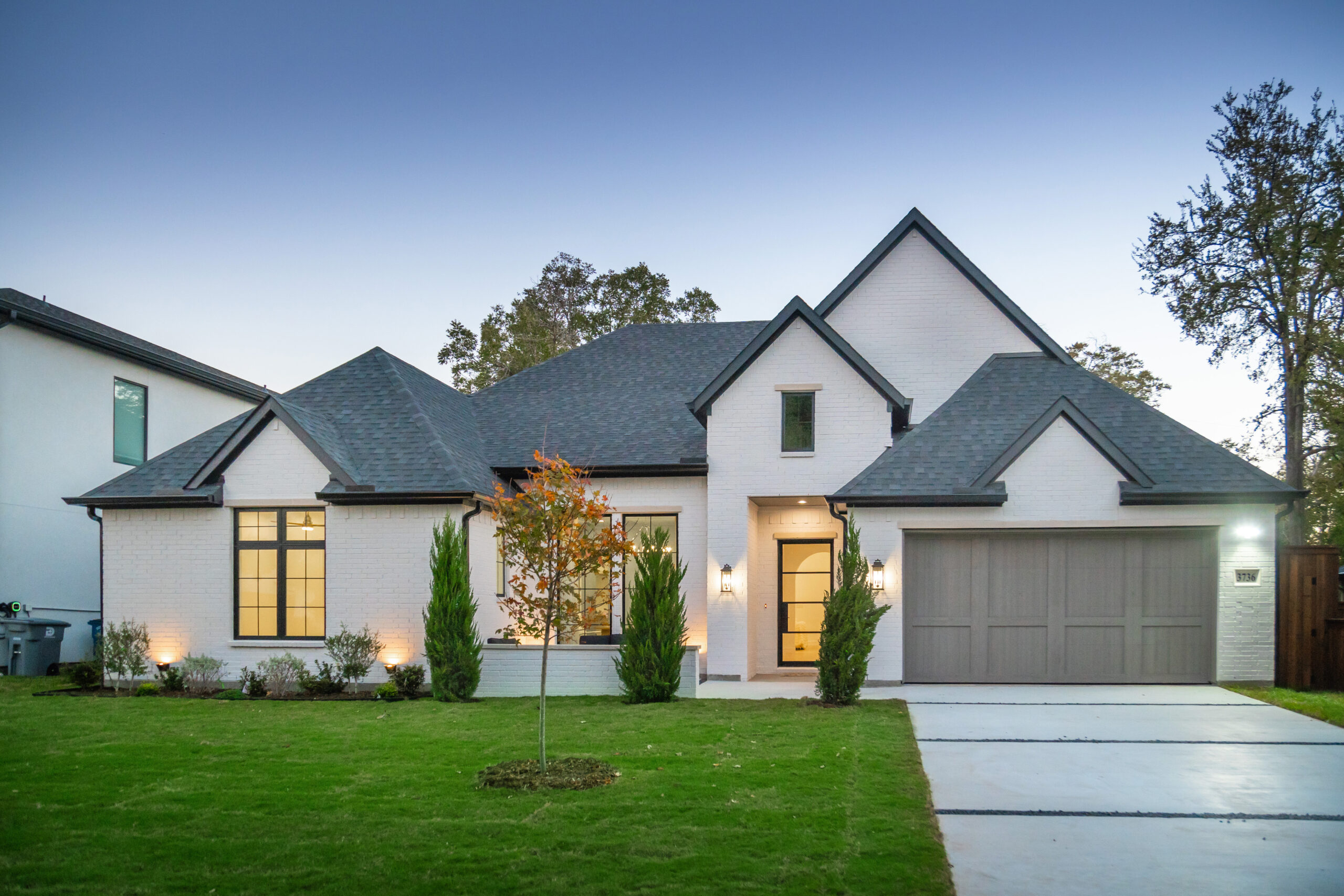 Modern suburban house with gray roof and white exterior.