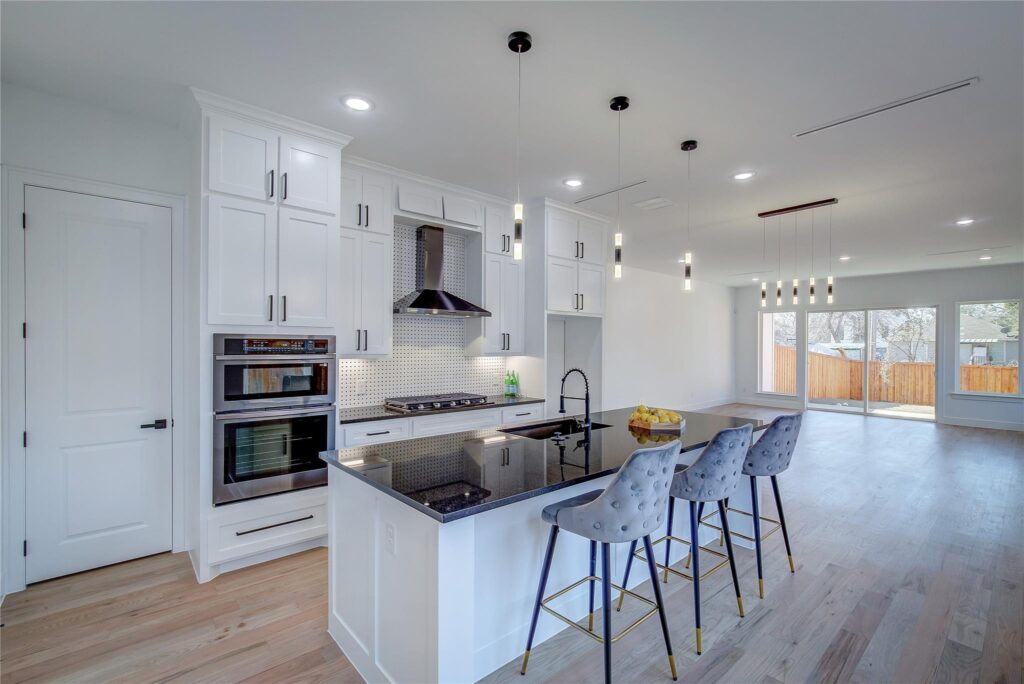 Modern kitchen with white cabinetry and a large island with bar stools.
