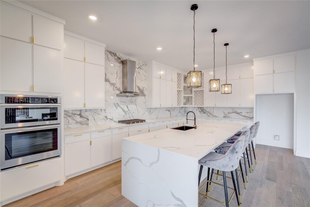 Modern kitchen with marble countertops and island seating.