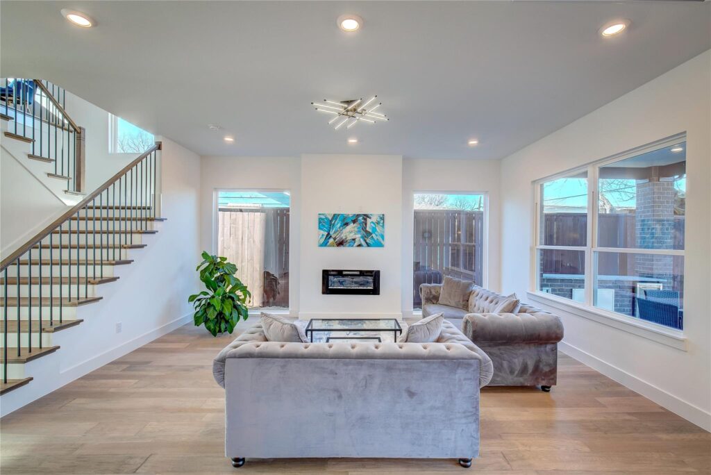 Bright modern living room with plush sofas and large windows.