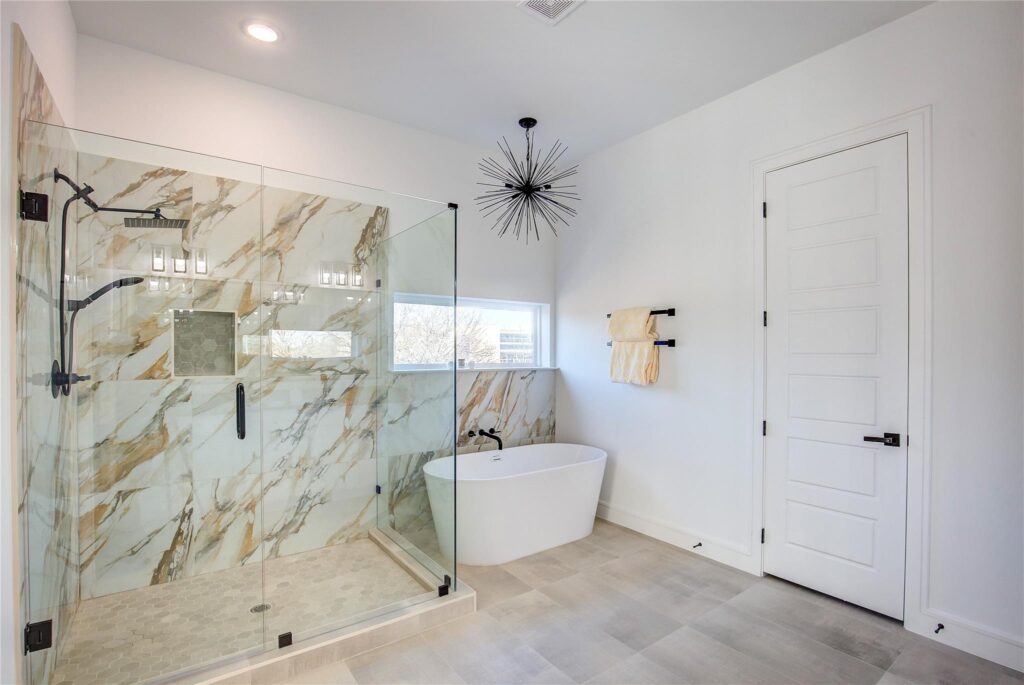 Modern bathroom with marble shower and freestanding tub.